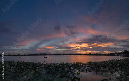 Lake view evening of many clouds moving in the sky with colorful red sun light in the sky background  sunset at Krajub reservoir  Banpong  Ratchaburi  Thailand.