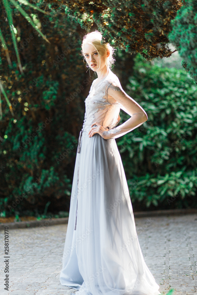 Stunning bride portrait in beautiful wedding dress on natural background.