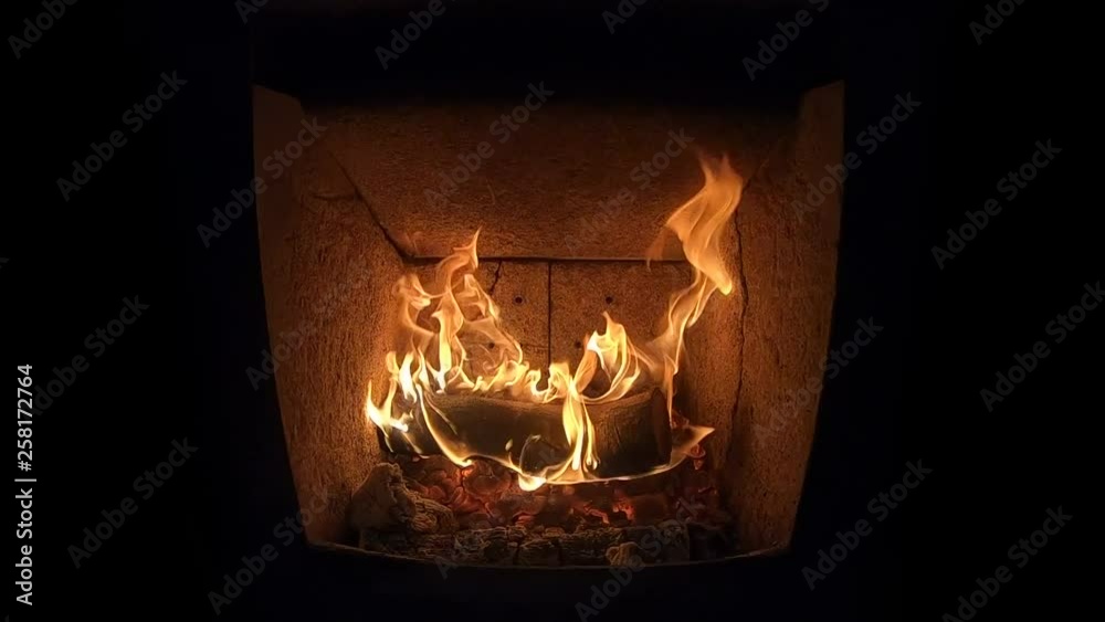 200 fps slow motion close up footage of a burning log lying on glowing coal in a fire place