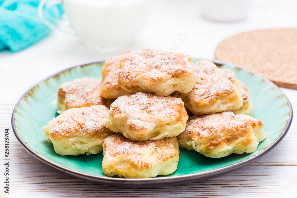 Ready-to-eat cottage cheese cookies on a plate on a wooden table.