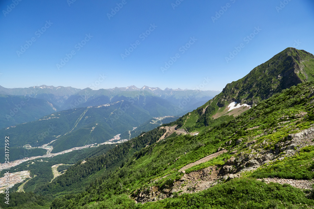 A panoramic view of the Valley with apartment buildings, surrounded by mountains with cable cars. A panoramic view of the Valley with apartment buildings, surrounded by mountains with cable cars.