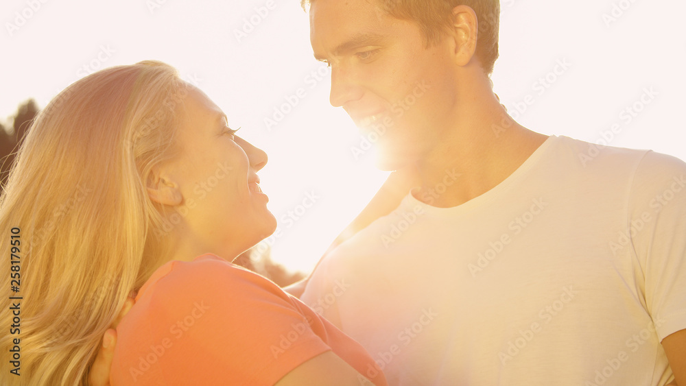 CLOSE UP: Young man looks deep into his girlfriends' eyes while holding her.