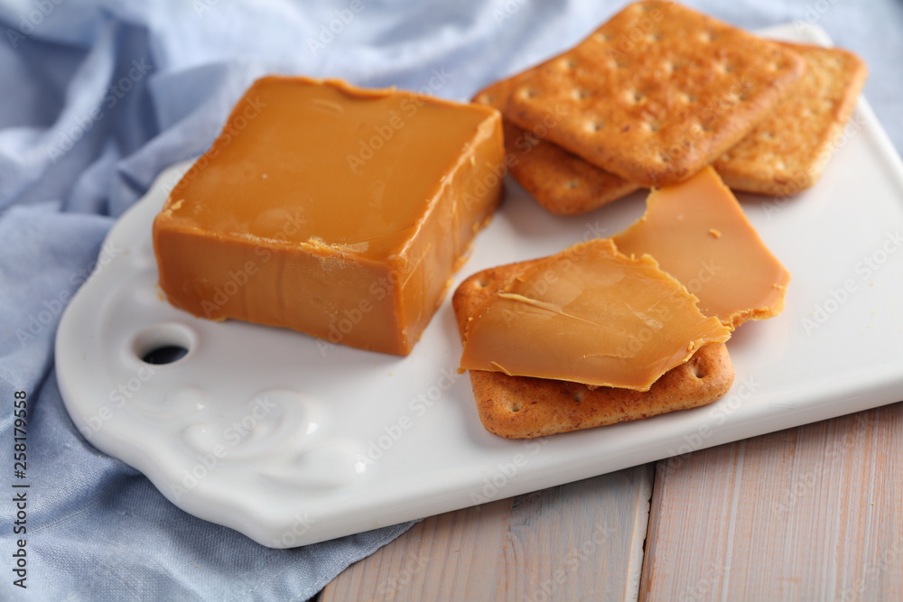 Crackers with Brunost, Norwegian Brown Cheese  on ceramic board