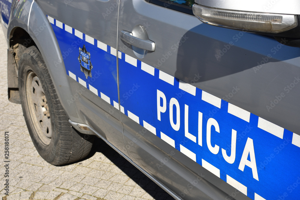Obraz premium Door of the Polish Police car with telephone number 112 and symbol of Police, closeup
