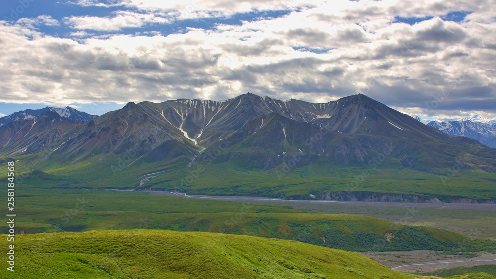 With its huge mountains and surrounded by a wonderful biodiversity lies the Denali National Park and Preserve. River, field and cloud sky. Landscape, fine art. Parks Hwy, Alaska, EUA: July 28, 2018