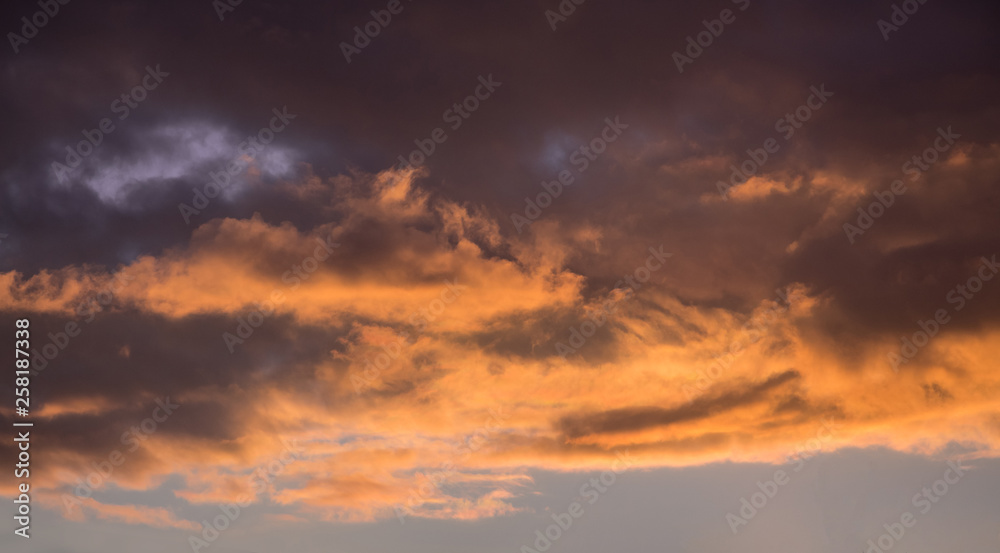 Dark dramatic orange-brown clouds during the sunset_