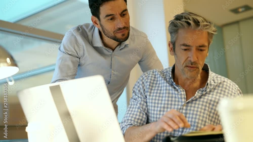 Casual businessmen discussing ideas infront of computer Casual businessmen discussing ideas infront of computer