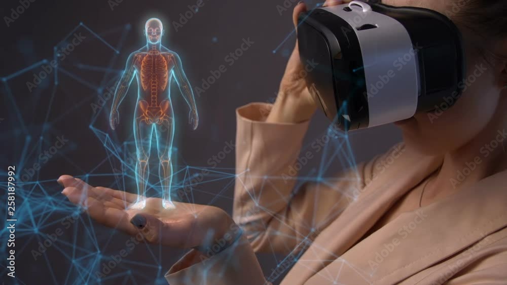 Young woman using a virtual reality headset with hologram rotating humans body skeleton and conceptual network lines and dots in her hand