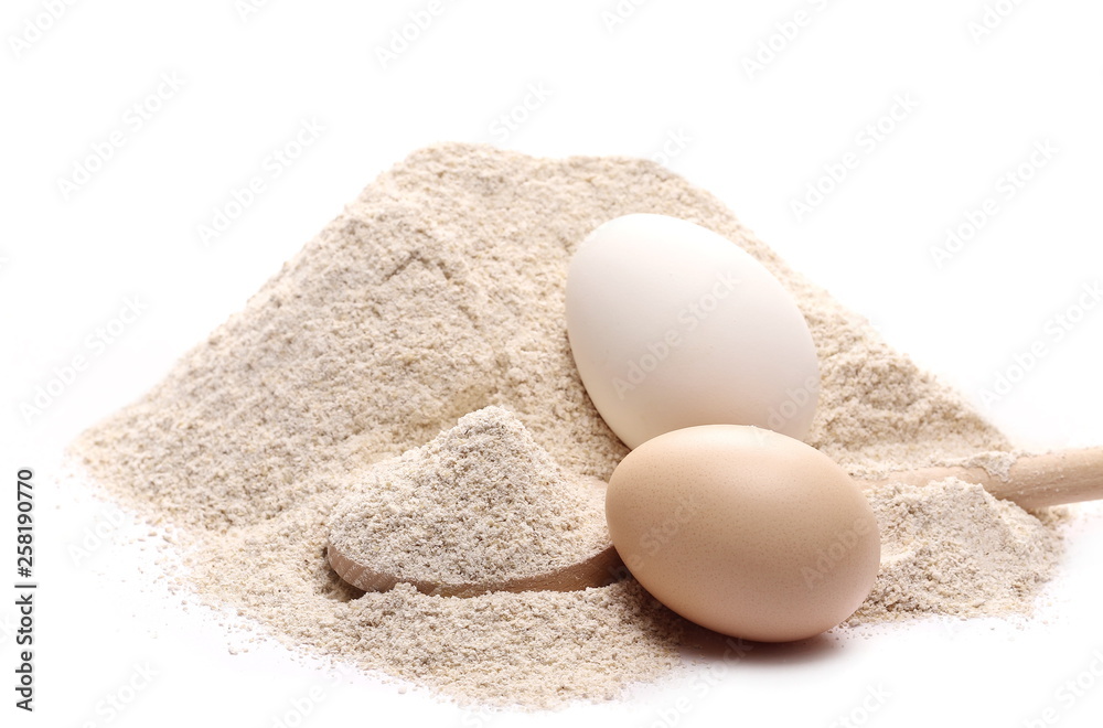 Integral barley flour pile with wooden spoon and eggs isolated on white background, clipping path Integral barley flour pile with wooden spoon and eggs isolated on white background, clipping path