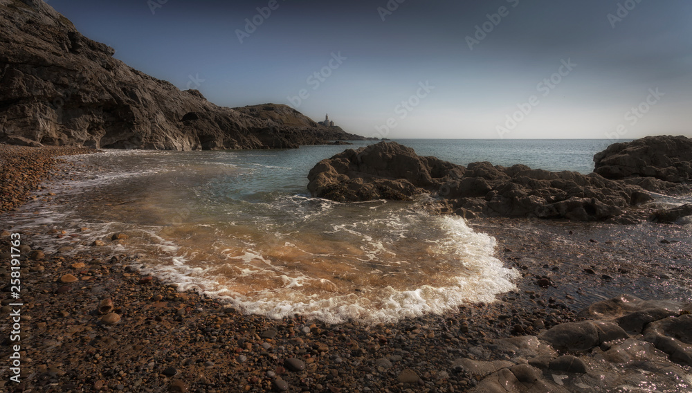 Obraz premium Incoming tide at Mumbles Lighthouse and Bracelet Bay on the Gower peninsula in Swansea, South Wales, UK.