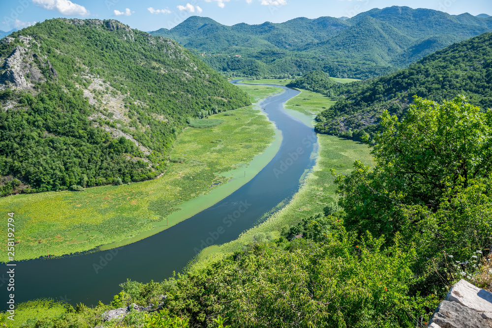 The picturesque meandering river flows among green mountains.