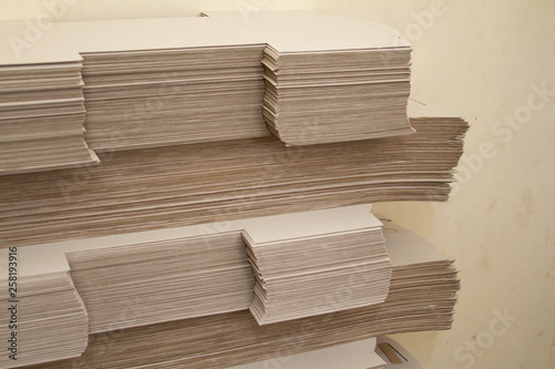 Many large stacks of brown paper against the background of recycled materials.