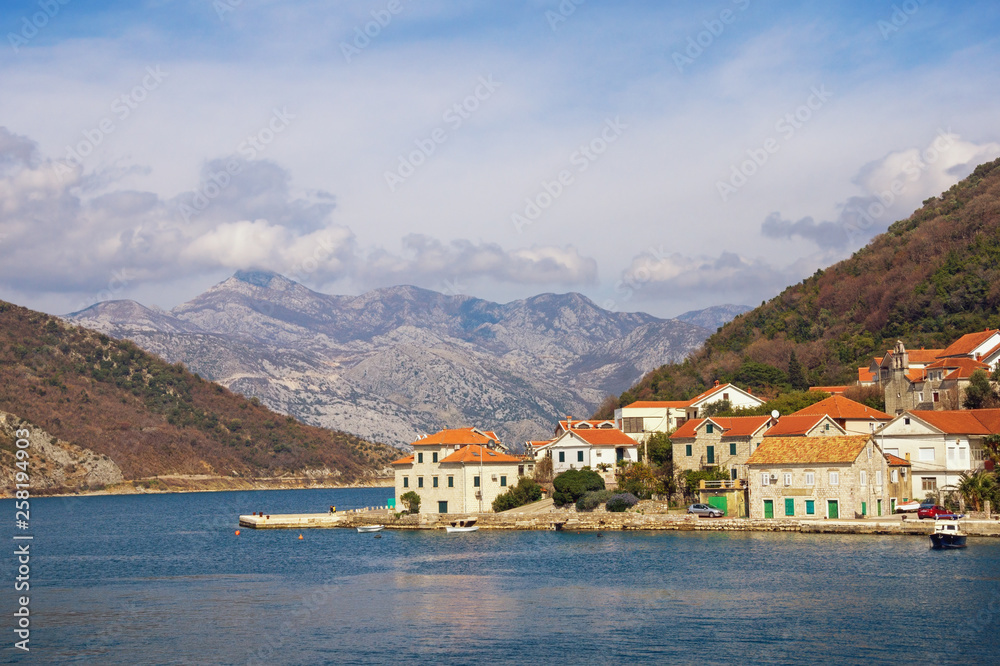 Beautiful Mediterranean landscape. Small seaside village at the foot of the mountains. Montenegro, Adriatic Sea, Bay of Kotor, Lepetane village
