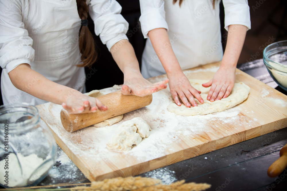 two girls make flour dough.