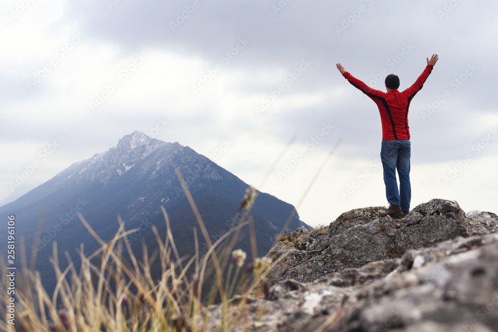 Man rise a hands on top of the mountain. Concept of freedom, man on wild nature in mountains Man rise a hands on top of the mountain. Concept of freedom, man on wild nature in mountains