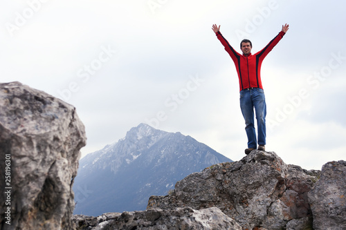 Man rise a hands on top of the mountain. Concept of freedom, man on wild nature in mountains