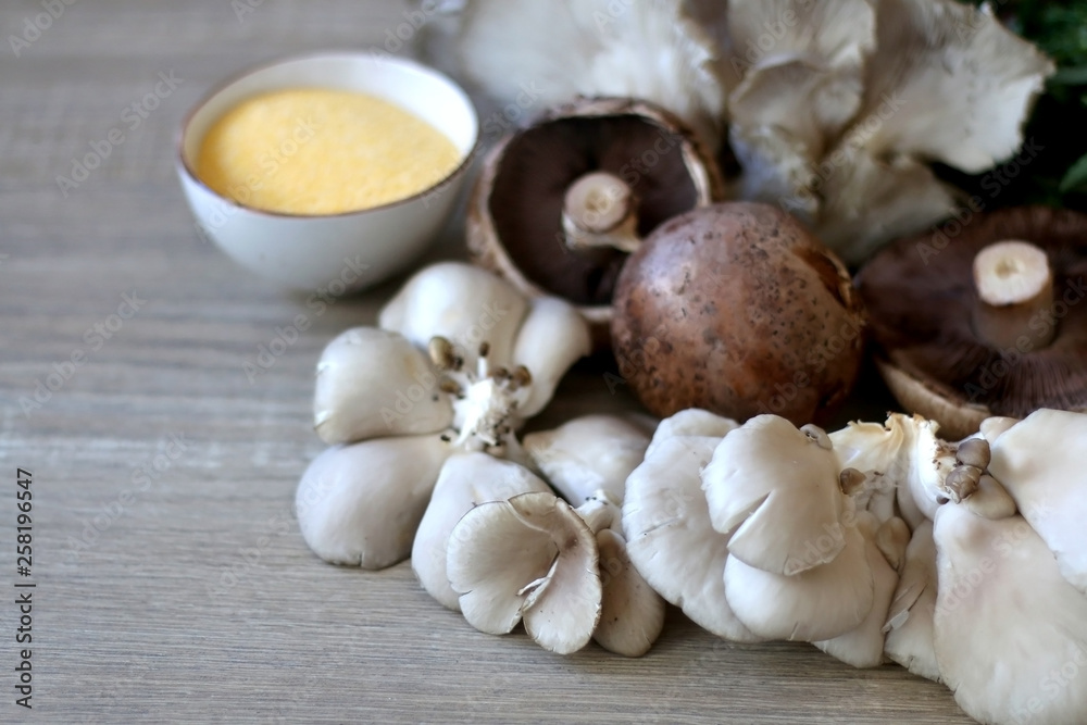 Champignon and oyster mushrooms, polenta, cheese and chicory on a wooden table. Ingredients for vegetarian lunch. Selective focus. Champignon and oyster mushrooms, polenta, cheese and chicory on a wooden table. Ingredients for vegetarian lunch. Selective focus.