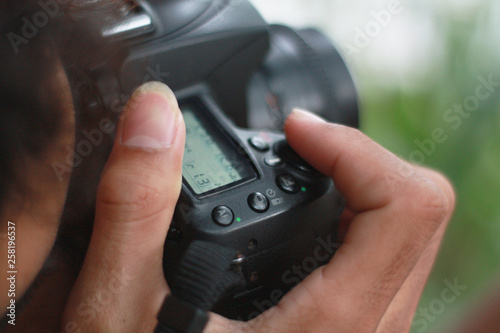 the hand of a man holding a camera