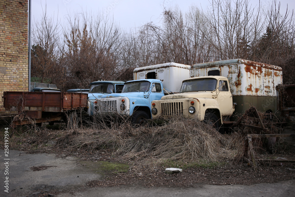 Abandoned old trucks refrigerators in the territory of the ravaged enterprise.