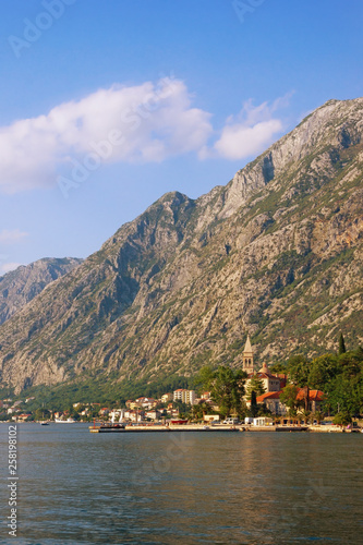 Beautiful Mediterranean landscape. Montenegro, Adriatic Sea. View of the Bay of Kotor and the seaside town of Dobrota at the foot of the mountains on a sunny summer day