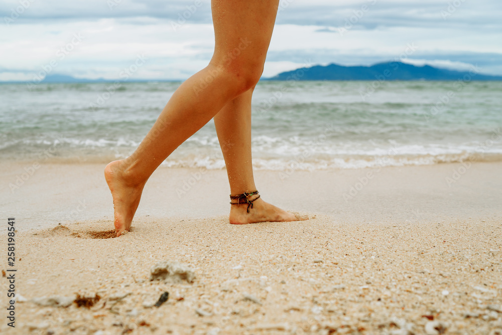 Woman walking on the beach leaving footprints in the sand Woman walking on the beach leaving footprints in the sand
