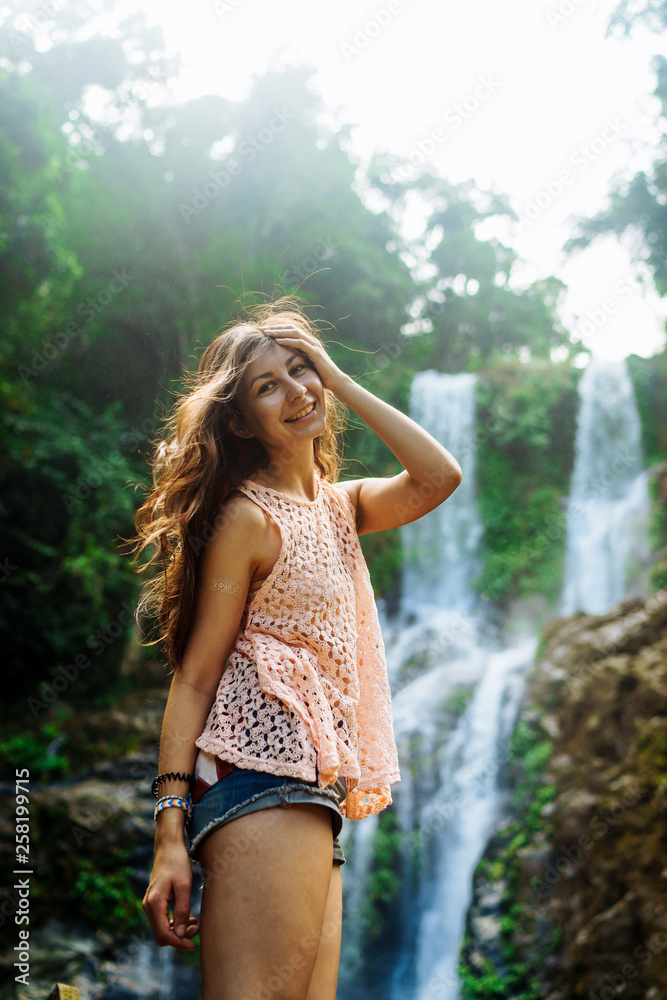 Young woman enjoying natural bathing by the Tamaraw waterfall on background. Puerto Galera, Mindoro Island, popular tourist place of Philippines Young woman enjoying natural bathing by the Tamaraw waterfall on background. Puerto Galera, Mindoro Island, popular tourist place of Philippines