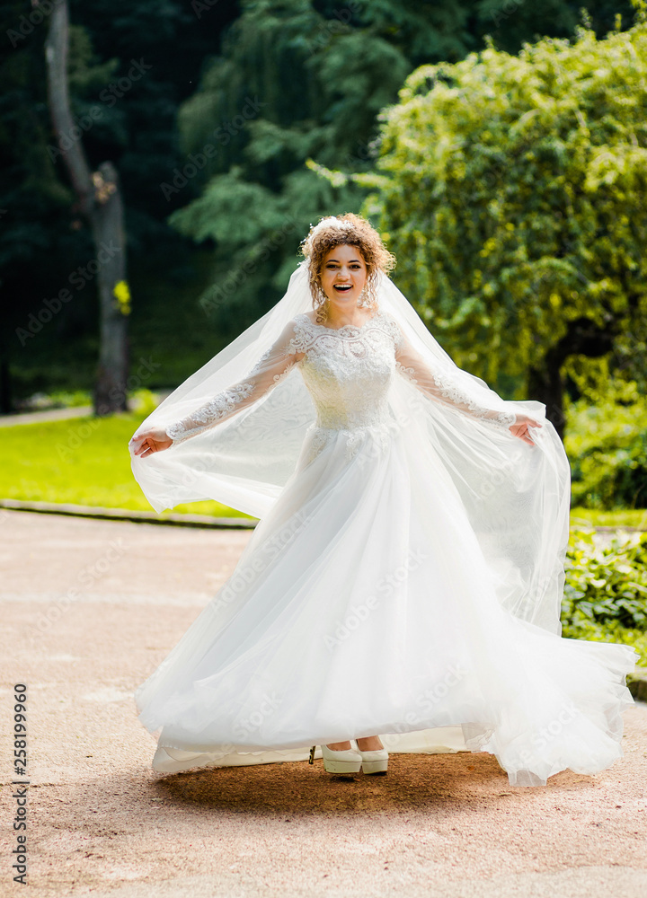 Sweet bride in a white dress .whirl in the park
