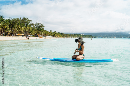 Woman is enjoying a view in standup paddleboarding over the ocean