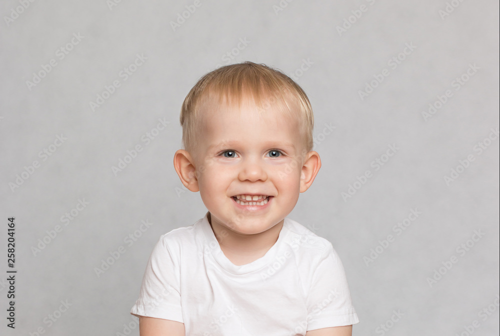 Fototapeta premium little cute toddler boy laughing provocatively on white background