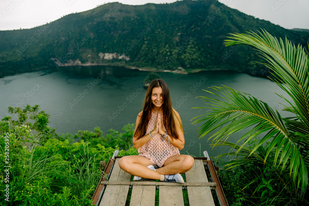 Woman sitting in front of green lake, Taal Volcano, Tagaytay, Philippines Woman sitting in front of green lake, Taal Volcano, Tagaytay, Philippines