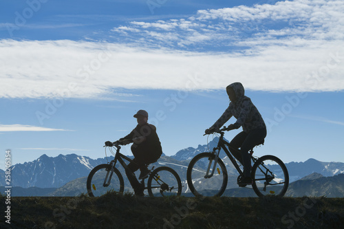 Two Cyclists Against Mountain Landscape