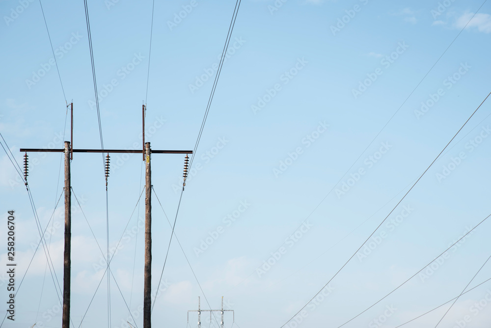 Electric poles with wires and cables set on a bright blue daylight sky. Electric poles with wires and cables set on a bright blue daylight sky.