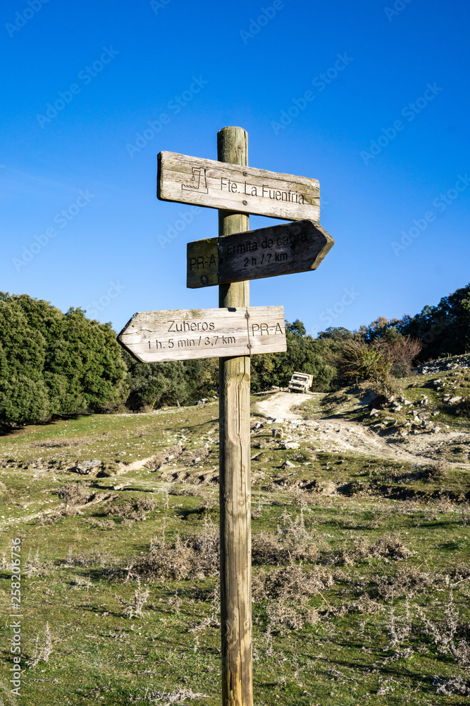 view of wooden directional signs on a pole. Hiking next to zuheros