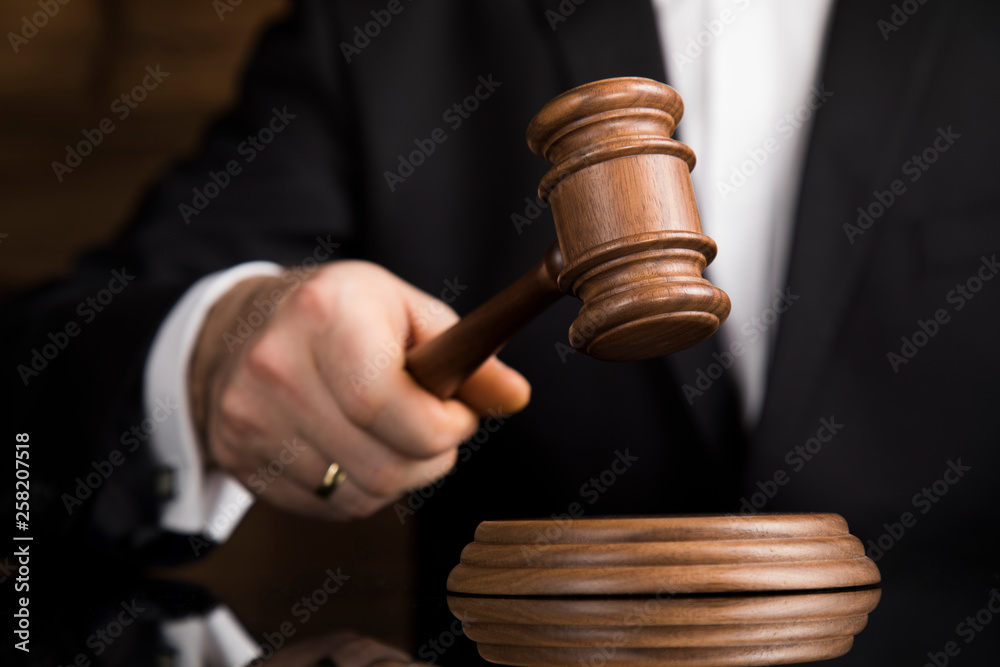 Judge, male judge in a courtroom striking the gavel Judge, male judge in a courtroom striking the gavel