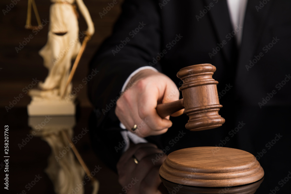 Judge, male judge in a courtroom striking the gavel Judge, male judge in a courtroom striking the gavel