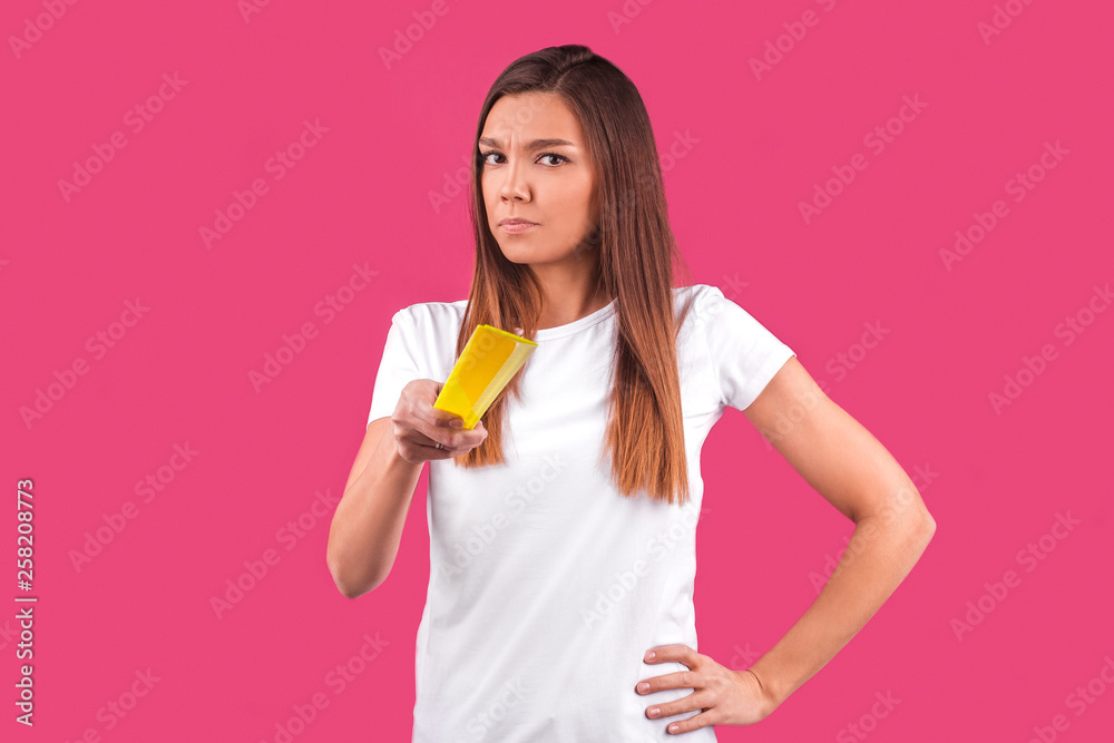 a young girl pointed a yellow plastic ruler directly at the camera on a pink background a young girl pointed a yellow plastic ruler directly at the camera on a pink background