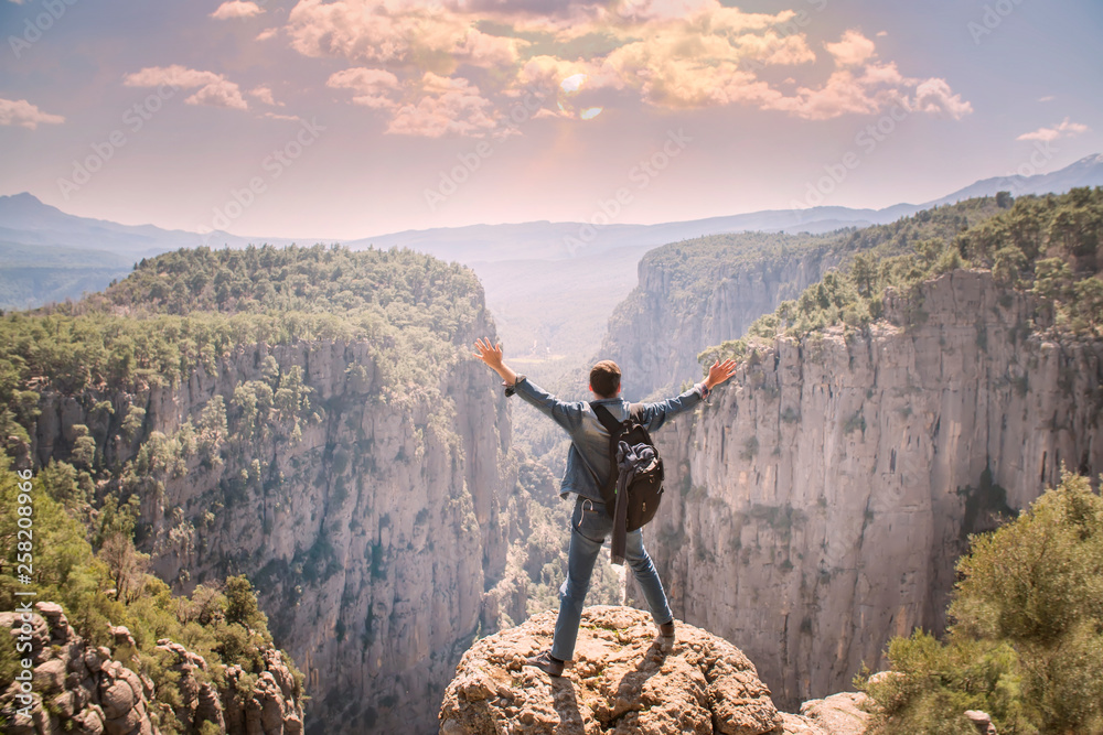Obraz premium Young traveller enjoying a looking at sunset on Panoramic mountains view. Traveling, active lifestyle concept
