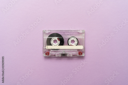 Close-up of an old audio cassette in the center on purple background. Place for text.