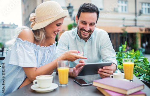 Young couple sitting in the cafe and having fun with tablet. Dating, relationships, love, romance, lifestyle, technology