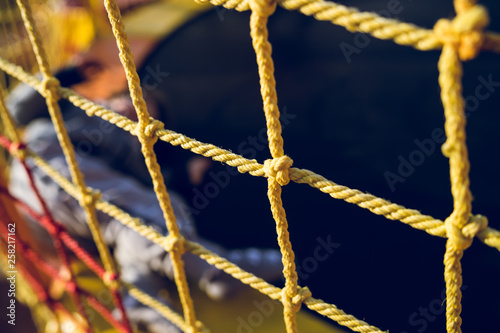 Close up on the yellow safety net at the playground against dark background