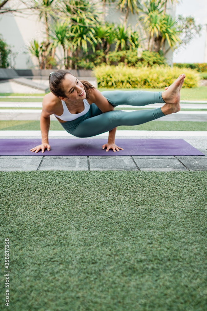 Obraz premium Beautiful Yoga teacher warm up before do Yoga practice. Portrait of young woman practice yoga outdoor.