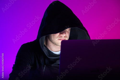 Closeup photo handsome man working on laptop anonymously