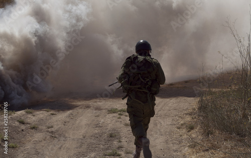 A soldier ran through thick smoke