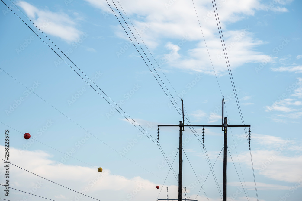 Electric poles with wires and cables set on a bright blue daylight sky. Electric poles with wires and cables set on a bright blue daylight sky.