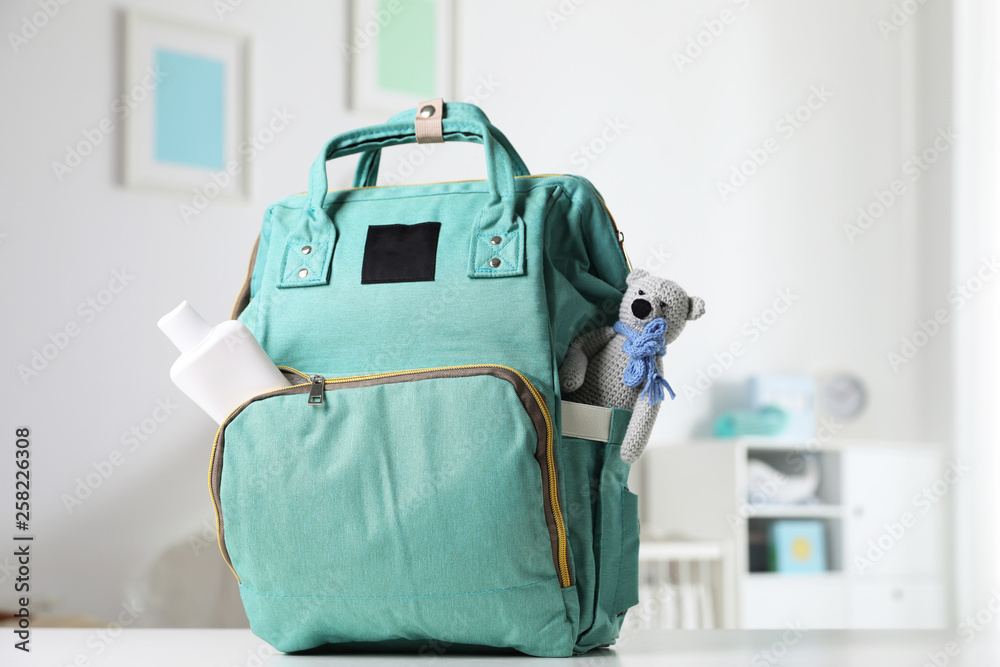 Maternity backpack with baby accessories on table indoors - obrazy, fototapety, plakaty 