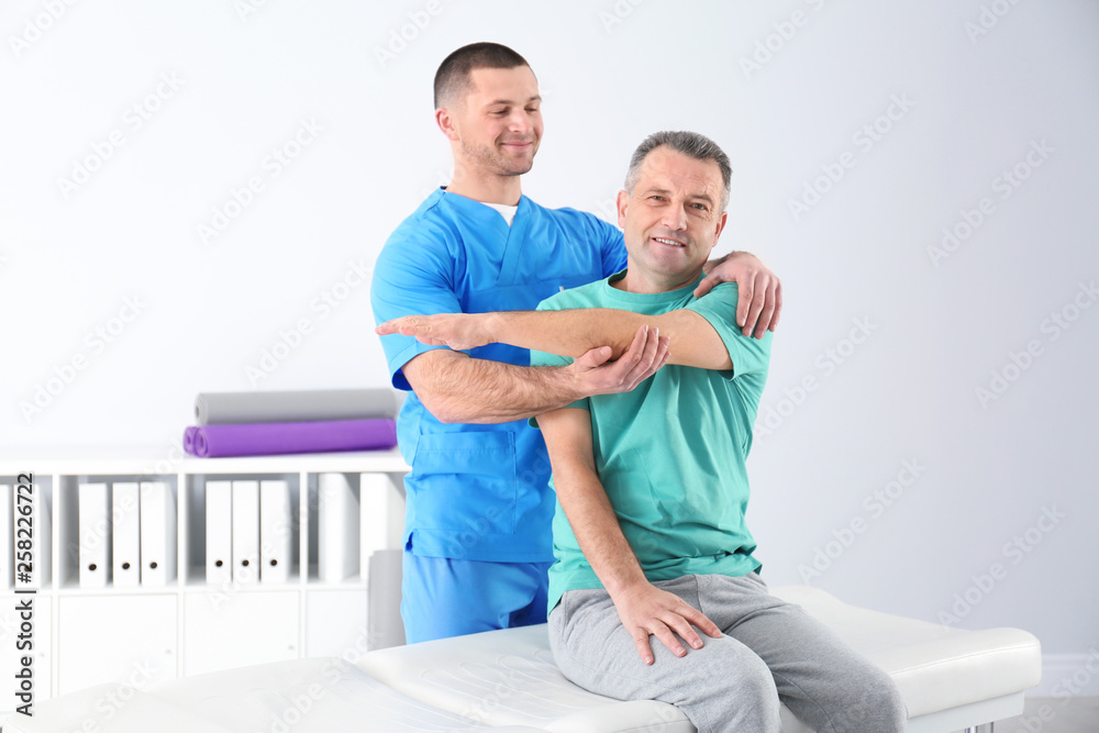 Fototapeta premium Doctor working with patient in hospital. Rehabilitation physiotherapy