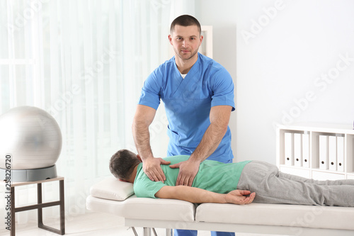 Doctor working with patient in hospital. Rehabilitation massage