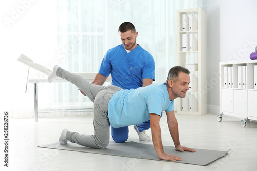 Doctor working with patient in hospital. Rehabilitation exercises