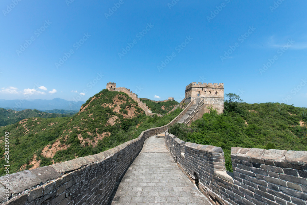 Panorama of Mutianyu, a section of the Great Wall of China. Mountains and hill ranges surrounded by green trees during summer. Huairou District, Beijing, China