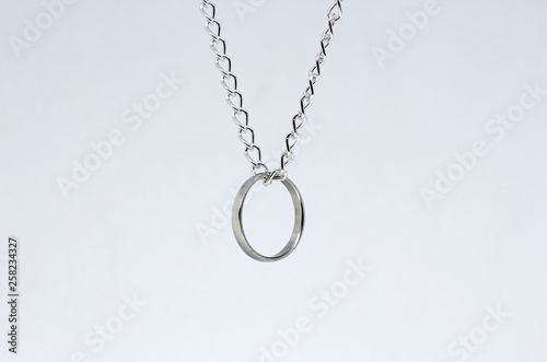 Silver ring hanging in chain. Isolated on white background